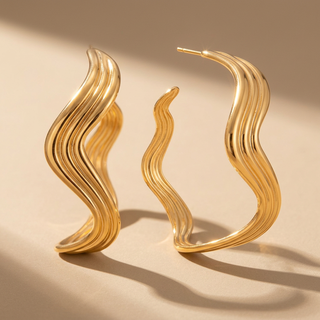 gold large wavy hoops on studio background