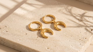 Slim hoops with moon charm drops on a sunlight marble base
