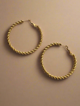 Gold hoop earrings on a light gray background