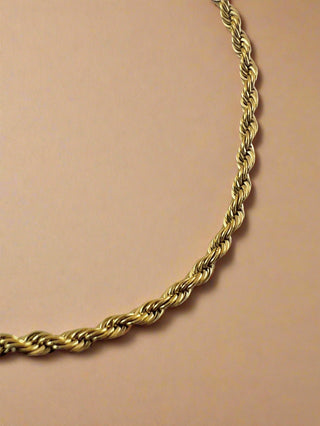 Gold rope chain on a light gray background