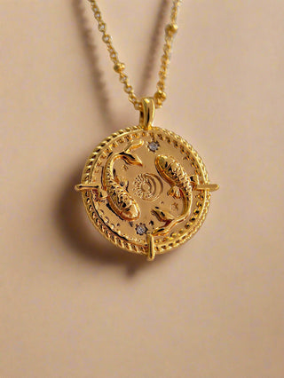 18k gold plated Pisces Necklace with cubic zirconia stones and fish design on the front of a round pendant with fine ball chain from - Gold Lunar. Horoscope star sign.