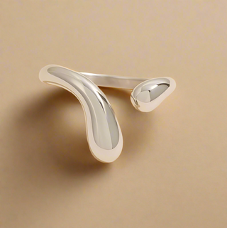 Silver ring with a unique design on a beige background