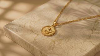 Gold necklace with a pendant on a marble surface