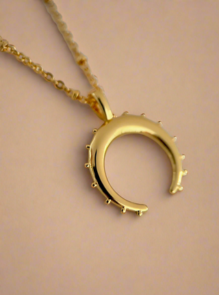 18k gold plated crescent moon necklace on fine ball chain on a jewellery dish