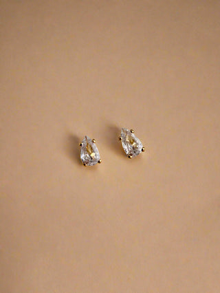 Cubic zirconia dainty teardrop stud earrings in 18k gold plated brass displayed on jewellery dish