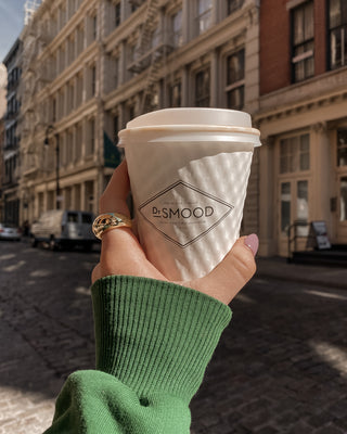 model in nyc wearing a gold lunar ring holding a coffee cup