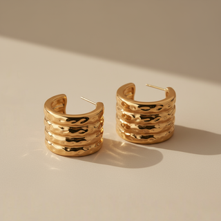 Pair of gold hoop earrings on a beige background
