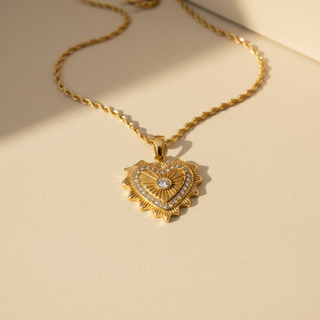 Gold heart-shaped necklace with a diamond on a beige background