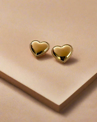 Puffy heart stud earrings with intricate detailing around the edge displayed on w white jewellery dish