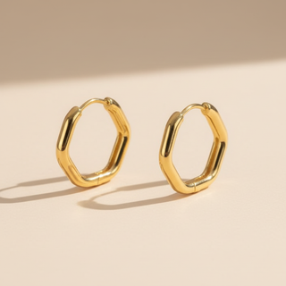 Gold hoop earrings on a beige background