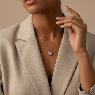 Woman wearing a beige blazer and a necklace with a heart pendant.
