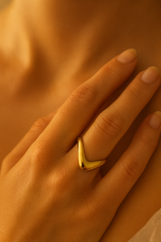 Gold ring on a hand with a warm, soft focus background