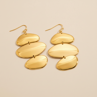 Pair of gold earrings on a beige background
