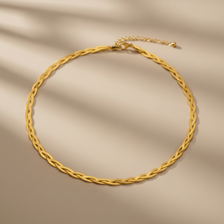 Gold braided necklace on a beige fabric background