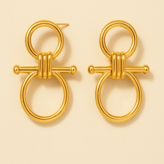 Pair of gold earrings on a beige background