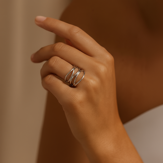 Hand wearing a silver ring with a plain background