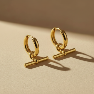 Gold hoop earrings with additional bars on a beige background