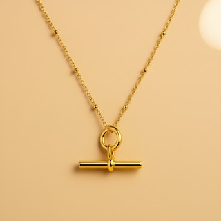 Gold necklace with a unique pendant on a beige background