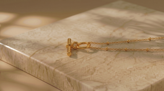 Gold bracelet on a marble surface
