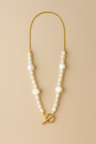 Pearl necklace with a gold clasp on a beige background