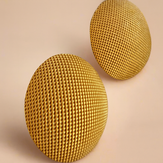 Two gold textured round studs on a beige background